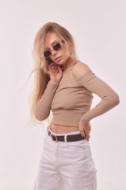 Portrait d'heureuse charmante jeune fille blonde gaie souriante à l'air heureuse et heureuse animée avec un maquillage naturel bronzé vêtu d'un t-shirt décontracté à manches longues