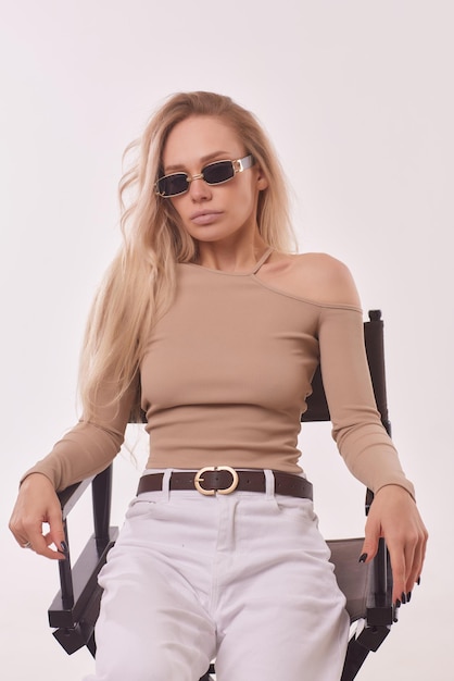 Portrait d'heureuse charmante jeune fille blonde gaie souriante à l'air heureuse et heureuse animée avec un maquillage naturel bronzé vêtu d'un t-shirt décontracté à manches longues