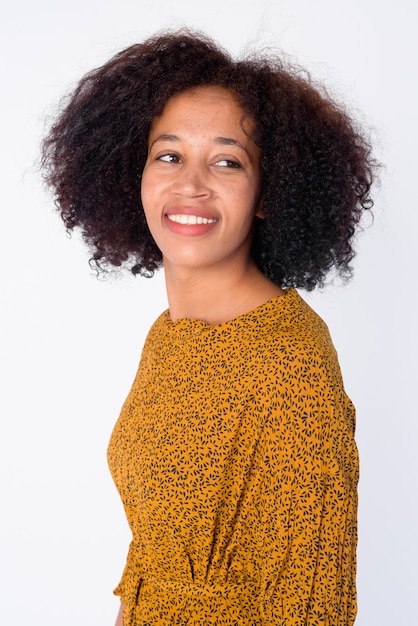 Portrait d'heureuse jeune belle femme africaine pensant et regardant en arrière