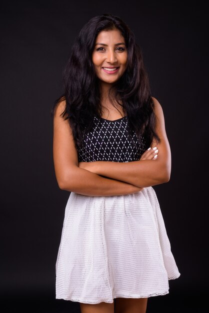 Portrait de l'heureuse jeune femme indienne belle souriante avec les bras croisés