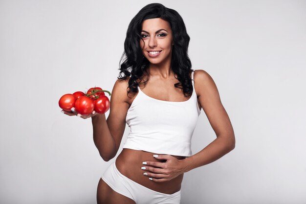 Portrait d'heureuse jeune femme à la tomate