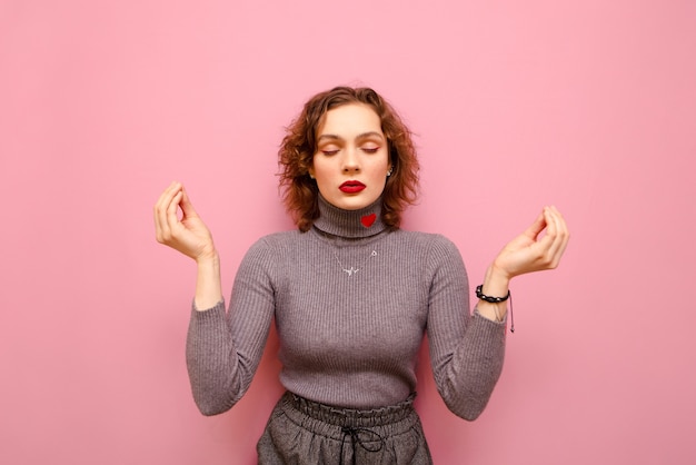 Portrait de l'heureuse jolie dame en pull gris et cheveux bouclés