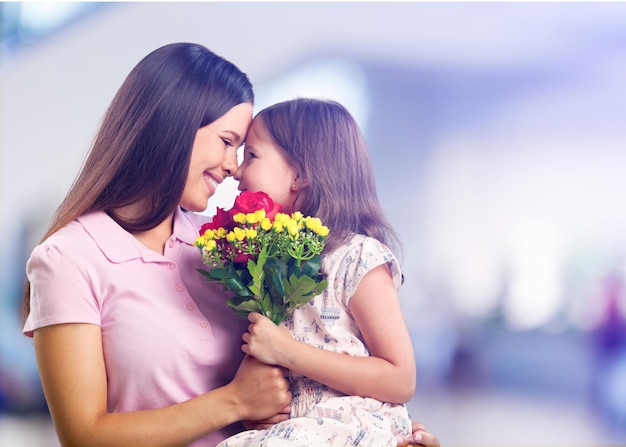 Portrait d'heureuse mère et fille tenant des fleurs