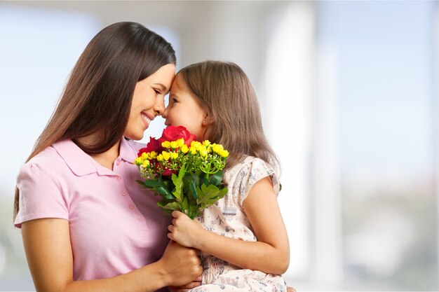 Portrait d'heureuse mère et fille tenant des fleurs