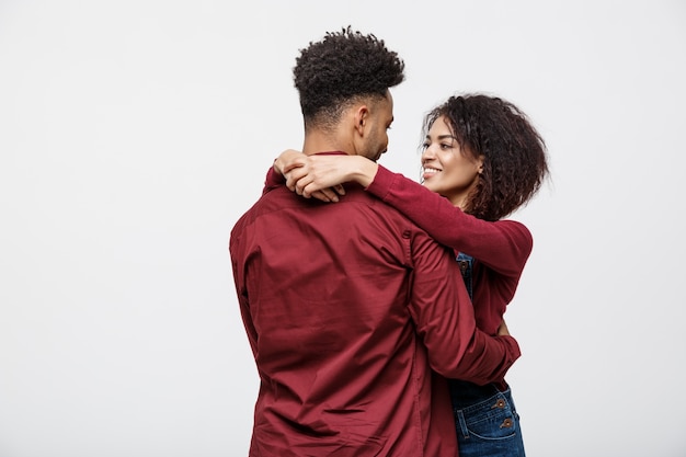 Portrait de l&#39;heureux couple afro-américain s&#39;embrassent sur fond blanc.