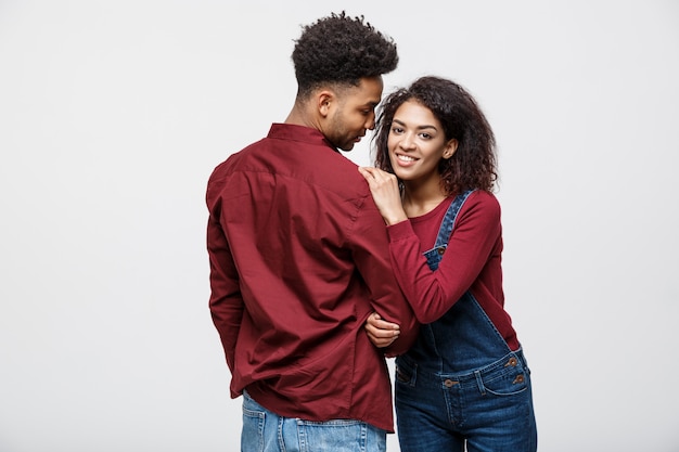 Portrait de l&#39;heureux couple afro-américain s&#39;embrassent sur fond blanc.