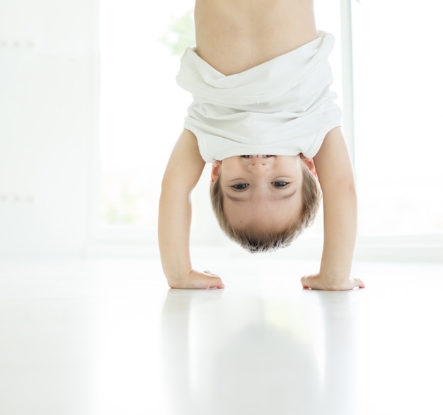 Portrait, de, heureux, enfant, jouer, envers, intérieur, dans, salon, sur, blanc, plancher, marche mains