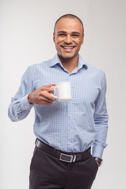 Portrait de l'heureux homme africain ayant une tasse de café