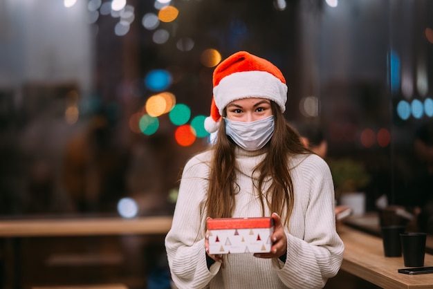 Portrait heureux jeune belle femme tenir la boîte-cadeau et sourire au café