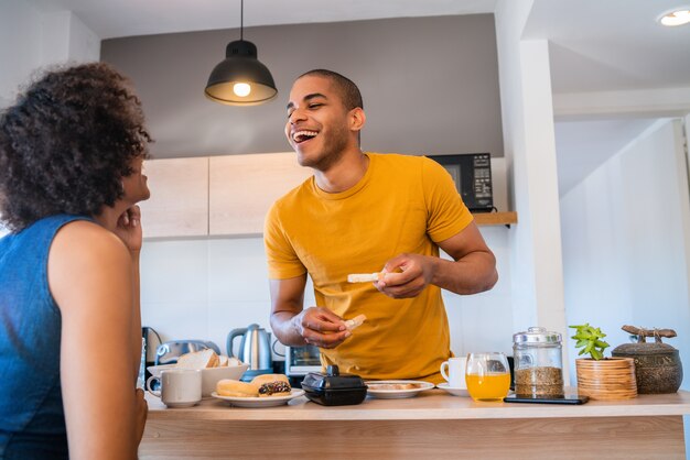 Portrait d'heureux jeune couple prenant son petit déjeuner ensemble à la maison. Concept de relation et de style de vie.