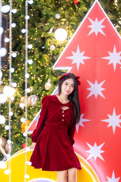 Portrait heureux jeune femme asiatique costume de Père Noël et décoration de colis photo de voeux de Noël sur la lumière de l'arbre de Noël Abstrait bokeh circulaire Décoration pendant Noël et nouvel an.