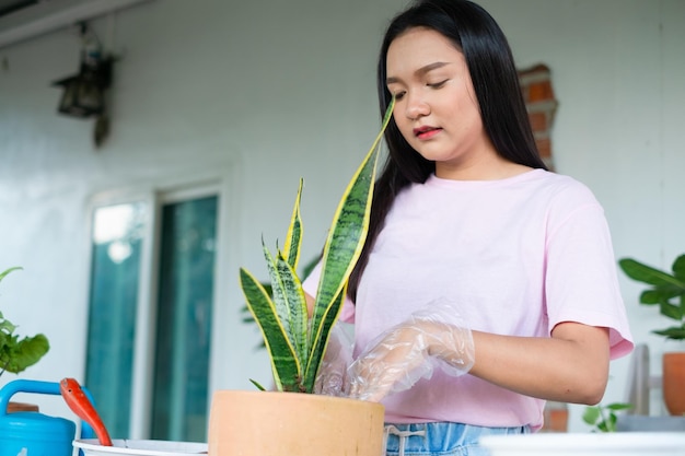 Portrait heureux jeune fille planter un arbre en pot à la maison