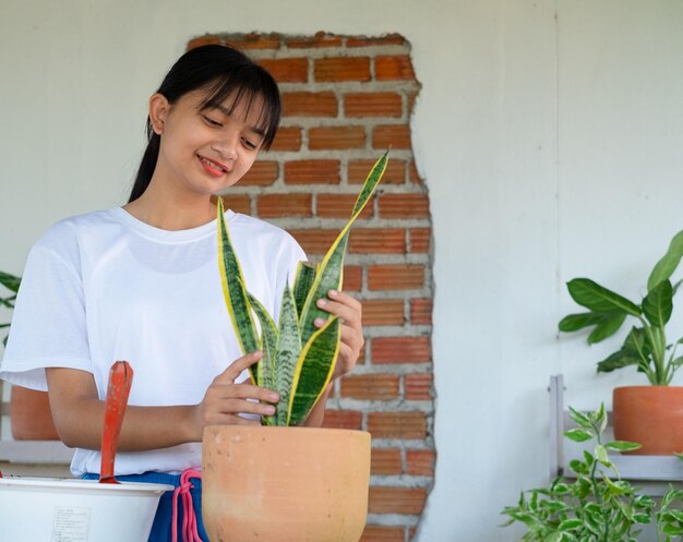 Portrait heureux jeune fille avec des plantes vertes à la maison