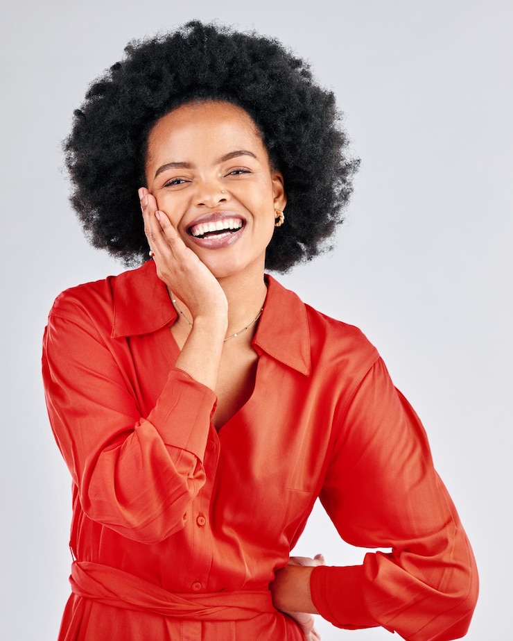 Photo portrait heureux et mode avec une femme noire afro en studio sur fond blanc pour un style branché sourire esthétique et vêtements rouges avec une jeune mannequin confiante posant dans une tenue vestimentaire