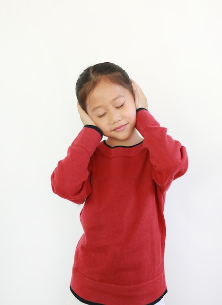 Portrait de l'heureux petit enfant asiatique plaçant les mains sur les oreilles