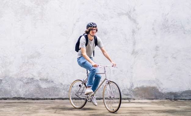 Portrait de hipster décontracté bel homme d'affaires avec sac à dos avec impatience tout en faisant la navette à vélo dans la rue chemin de la ville aller au travail concept de vélo de transport de voyage d'affaires