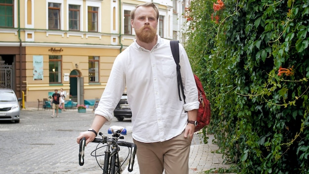Portrait de hipster masculin élégant avec vélo rétro dans la rue de la ville.