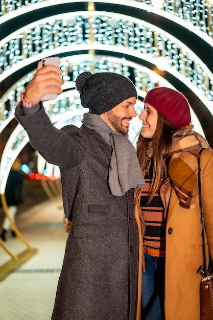 Portrait D'hiver D'un Couple Caucasien Appréciant Les Lumières De Noël