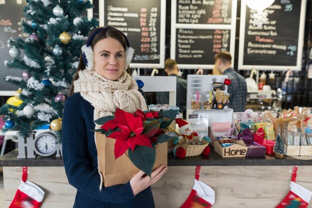 Portrait d'hiver de femme avec fleur de poinsettia rouge de Noël