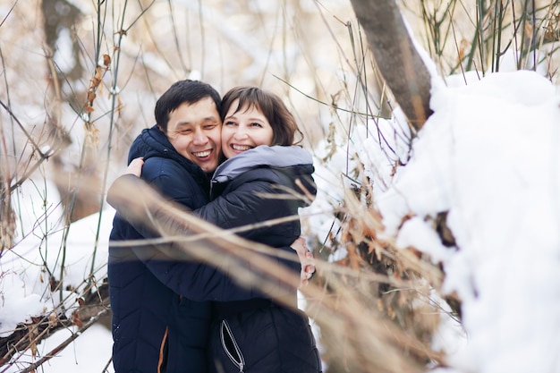 Portrait d'hiver d'un jeune couple interracial alors qu'ils s'embrassent