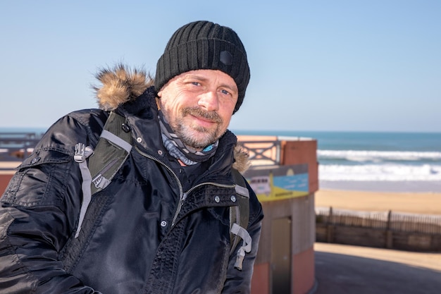 Portrait d'hiver en plein air d'un homme d'âge moyen barbe beau sur la côte de la plage de la mer