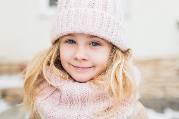 Portrait d'hiver de sourire enfant fille en bonnet et écharpe.