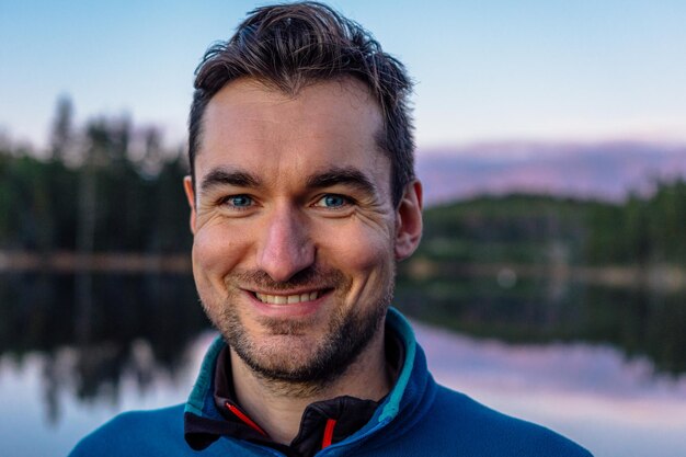 Photo portrait d'un homme adulte au milieu du lac contre le ciel au coucher du soleil