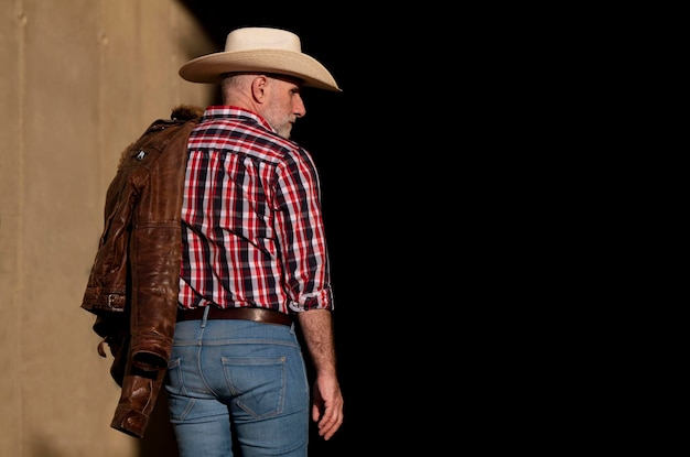 Portrait d'un homme adulte avec un chapeau de cow-boy sur un fond noir