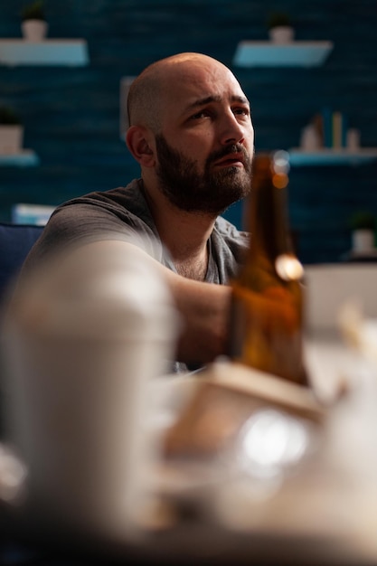 Portrait d'un homme adulte à mi-âge détournant le regard alors qu'il est assis dans une bouteille