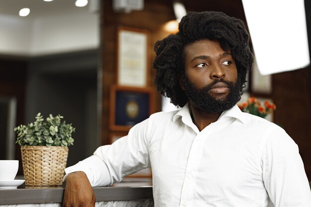 Portrait d'homme d'affaires afro-américain debout dans le hall de l'hôtel bouchent