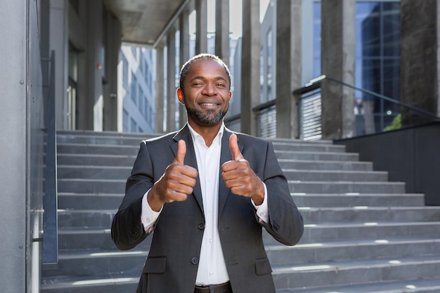 Portrait d'un homme d'affaires afro-américain prospère debout dans un costume à l'extérieur du centre de bureau