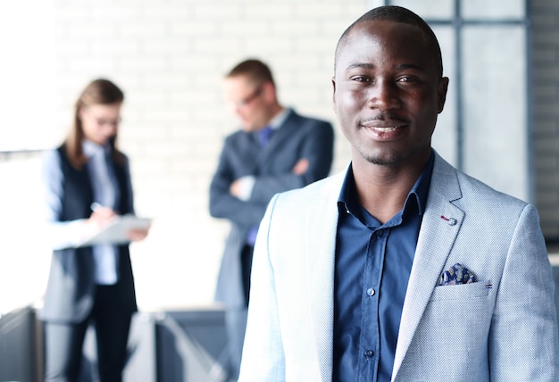 Photo portrait d'un homme d'affaires afro-américain souriant avec des cadres travaillant en arrière-plan