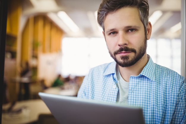 Portrait d'homme d'affaires à l'aide de tablette numérique au bureau