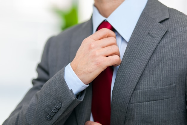 Portrait d&#39;un homme d&#39;affaires ajustant sa cravate