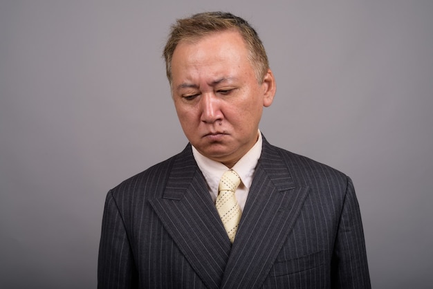 Portrait d'homme d'affaires asiatique mature sur fond gris