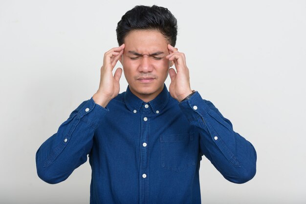 Portrait d'homme d'affaires asiatique stressé ayant des maux de tête