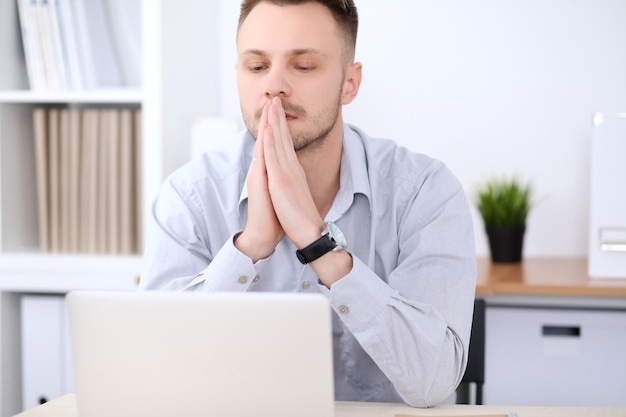 Portrait d'homme d'affaires assis au bureau en milieu de travail.