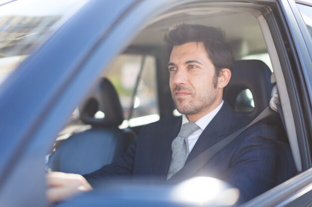 Portrait d&#39;un homme d&#39;affaires beau conduire sa voiture