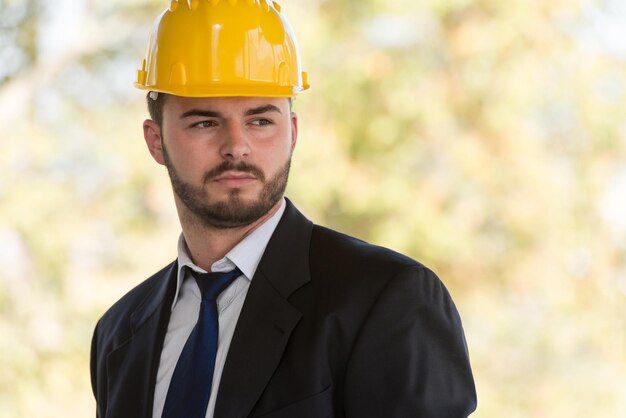 Portrait d'homme d'affaires avec casque jaune sur la construction