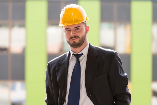 Portrait d'homme d'affaires avec casque jaune sur la construction