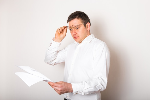 Portrait d'homme d'affaires caucasien drôle choqué surpris avec des lunettes ouvertes pour voir le rapport financier, le concept de mauvaises nouvelles