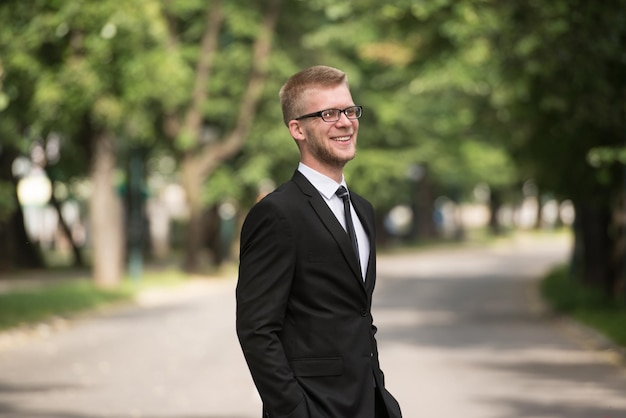 Portrait d'homme d'affaires confiant debout à l'extérieur dans le parc