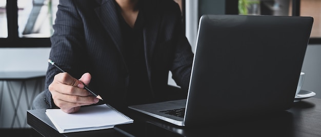 Portrait d'homme d'affaires en costume travaillant avec un ordinateur portable dans un bureau moderne.