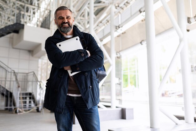 Portrait d'un homme d'affaires dans des vêtements décontractés intelligents avec un ordinateur portable avant un voyage d'affaires à la