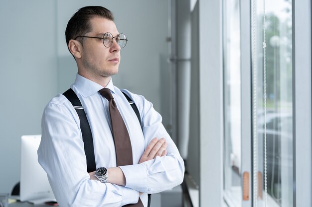 Portrait D'homme D'affaires Debout Par Fenêtre Au Bureau.