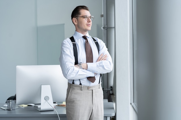 Portrait D'homme D'affaires Debout Par Fenêtre Au Bureau.