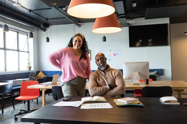 Photo portrait d'un homme d'affaires et d'une femme d'affaires multiraciaux souriants dans un bureau créatif