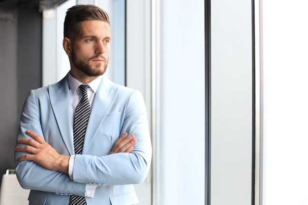 Portrait d'homme d'affaires heureux avec les bras croisés debout au bureau.