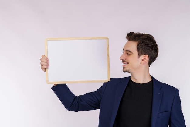 Photo portrait d'homme d'affaires heureux montrant une enseigne vierge sur fond blanc isolé