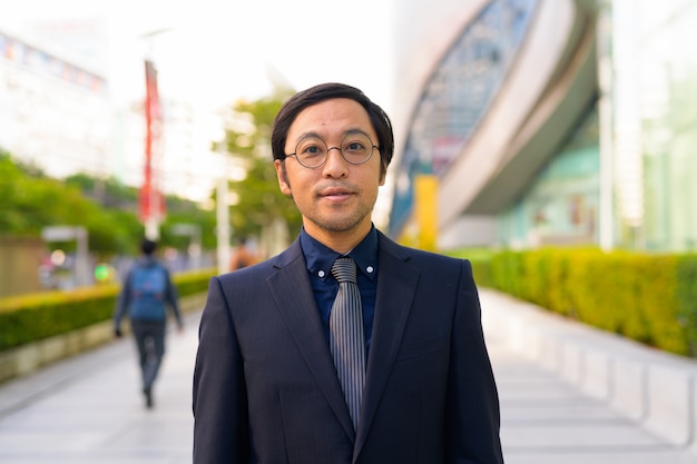 Portrait d'homme d'affaires japonais prendre l'air avec la nature dans la ville